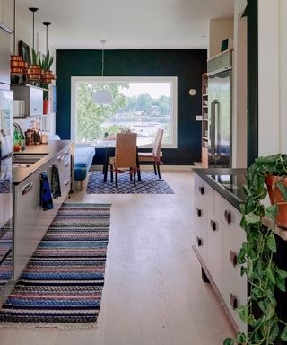 Galley kitchen layout with patterned runner and large window focal point