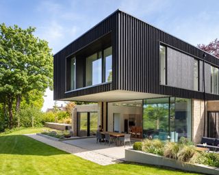 modern cantilevered house with outdoor dining space below