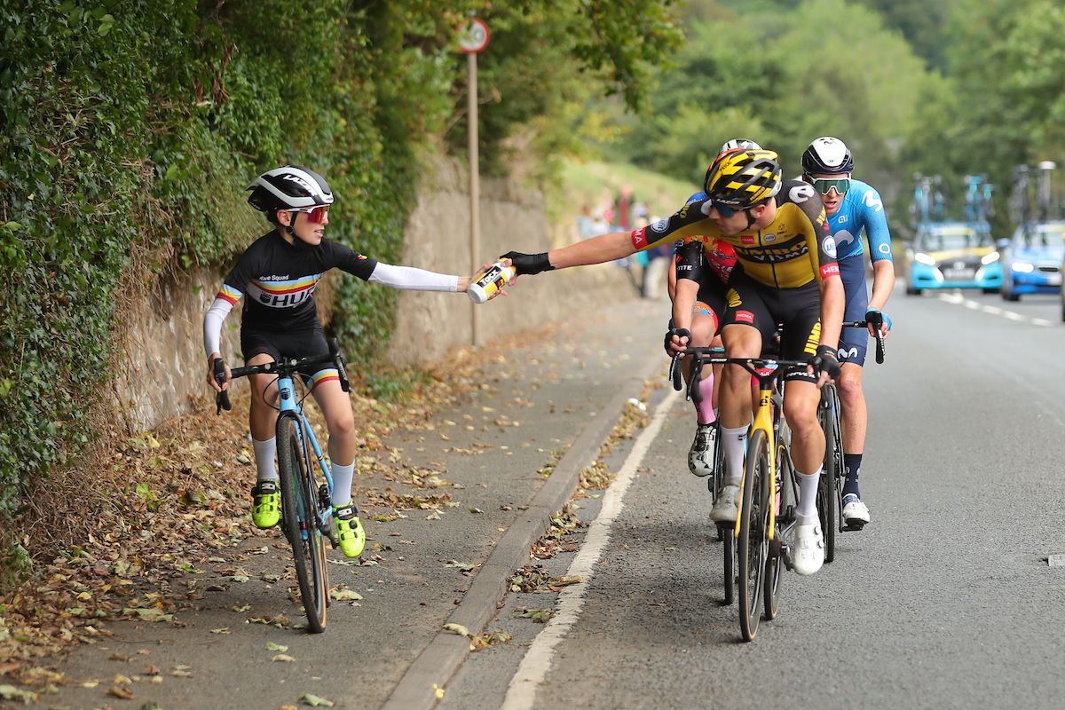 Picture by SWpixcom 11092021 Cycling AJ Bell Tour of Britain Stage 7 Hawick to Edinburgh Scotland Pascal Eenkhoorn of Jumbo Visma hands a bottle to a young cyclist riding along side the breakaway