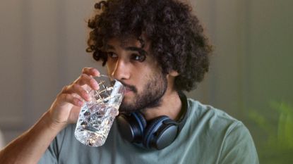 Man drinking water at desk