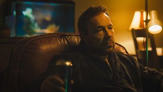 Andy (Stephen Graham) with beer in hand on a sofa in the Boiling Point TV series.