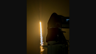 long range view of a rocket launching with another rocket in front