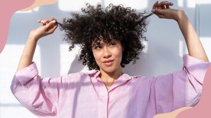 A woman with curly hait holding it up in her hands to demonstrate what is hair botox