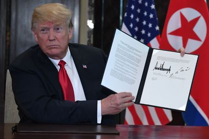 Trump shows the document he signed with Kim