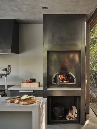 an outdoor kitchen with a pizza oven