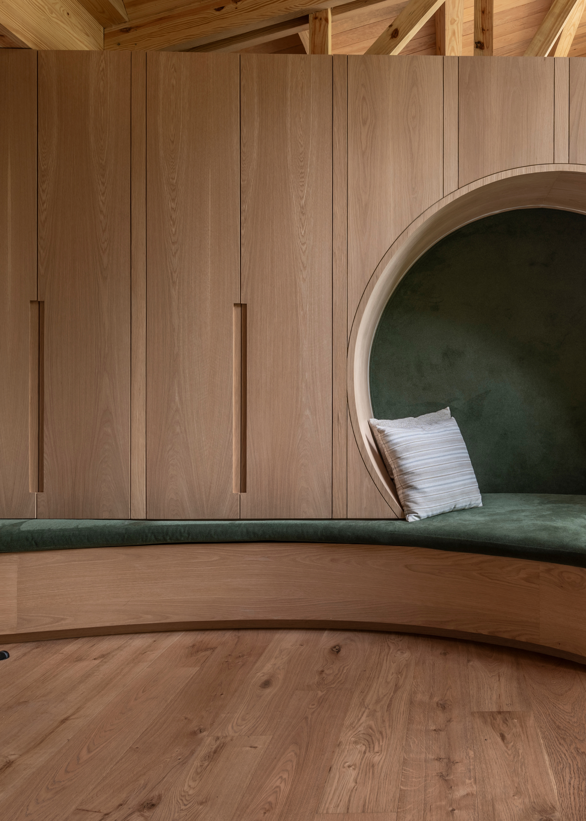 A wooden closet with plush green in-built bench seating