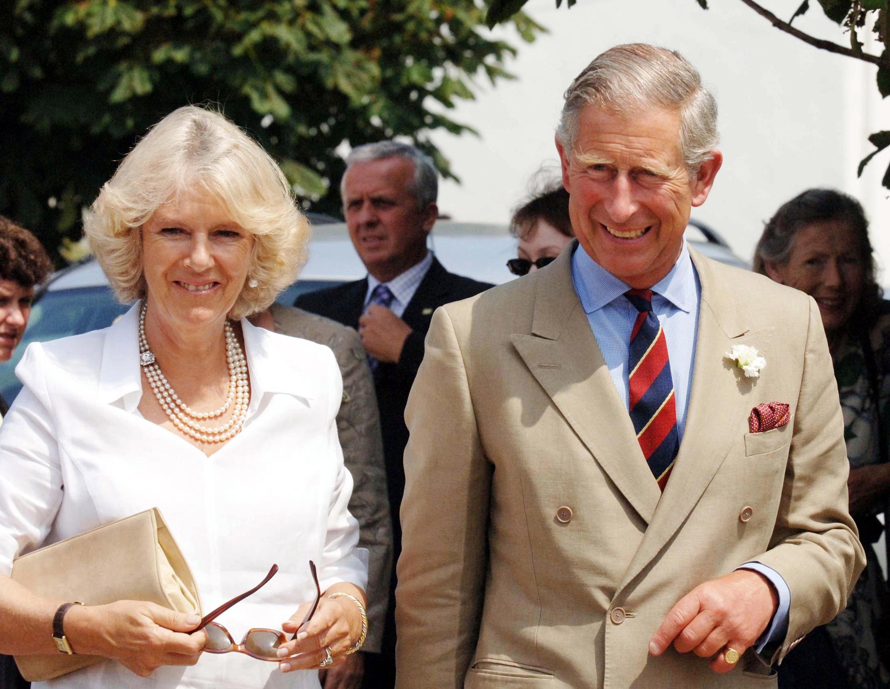 Queen Camilla and King Charles standing next to each other smiling in 2006