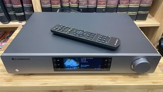 Cambridge Audio CXN100 music streamer from front/top with remote on wooden rack