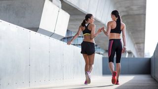a photo of two women walking in sports bras