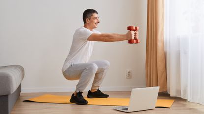 Man working out with dumbbells at home