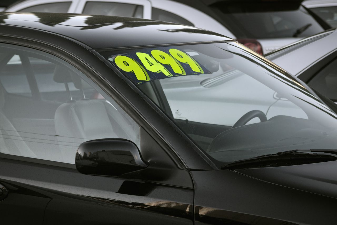 A price tag on a used car for sale.