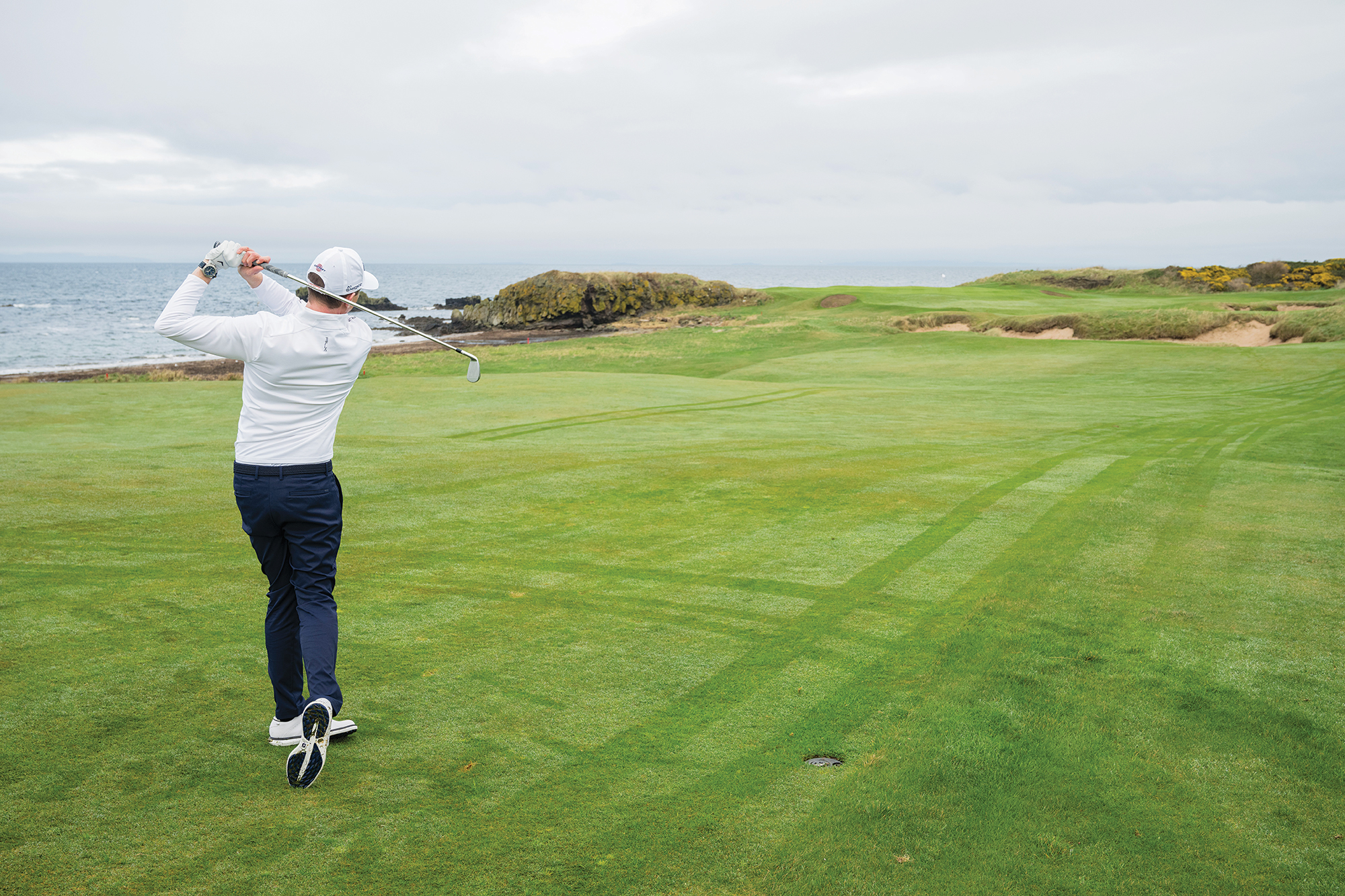Ben Emerson in the finish position after hitting a knock-down iron shot from the fairway at Trump Turnberry