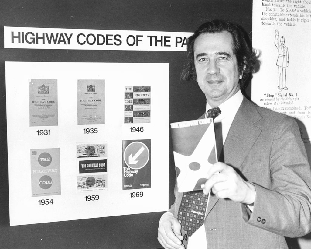 William Rodgers, Secretary of State for Transport, standing in front of Highway Code editions