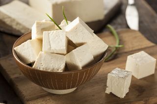 A bowl of plain tofu cubes sitting on a table