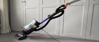 The Shark Anti Hair Wrap Upright Vacuum Cleaner with Powered Lift-Away NZ850UK being used to clean carpet