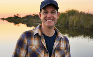 Matt Baker posing next to a lake