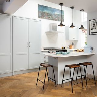 kitchen with white walls pastel cupoard and countertop with wooden metal tables