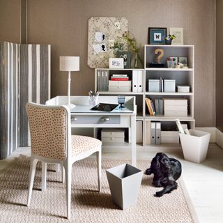 a beige neutralhome office with furniture from The Dormy House, including a desk, chair, shelves and a rug