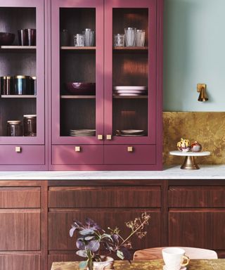 things that make a kitchen look cheap, plum colored glazed countertop unit, mahogany units, marble countertop, brass effect backsplash and table top