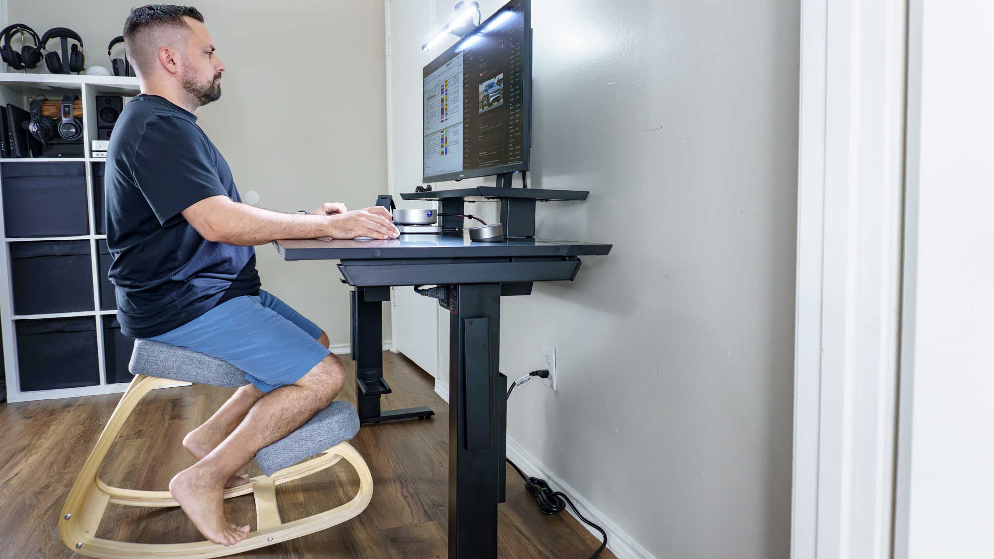 A person working at their desk sitting on a kneeling chair
