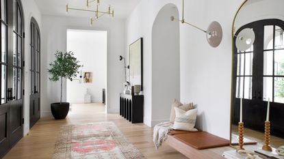 Large modern entryway with bench and cushions tucked away, indoor tree and more cozy elements