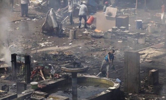 Supporters of deposed Egyptian President Mohammed Morsi throw rocks while taking cover among debris during a violent crackdown by Egyptian security forces in Cairo on Wednesday.