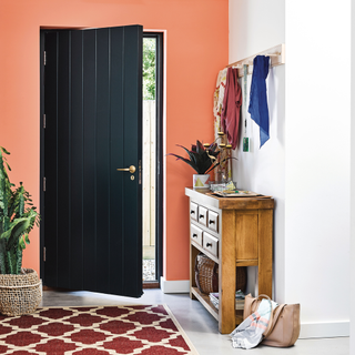 hallway with black door and orange wall