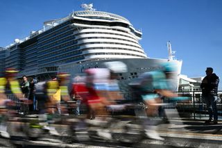 The breakaway rides past the Costa Smeralda passenger ship in Savona during the 115th Milan-SanRemo one-day classic cycling race, between Pavia and SanRemo, on March 16, 2024. (Photo by Marco BERTORELLO / AFP)