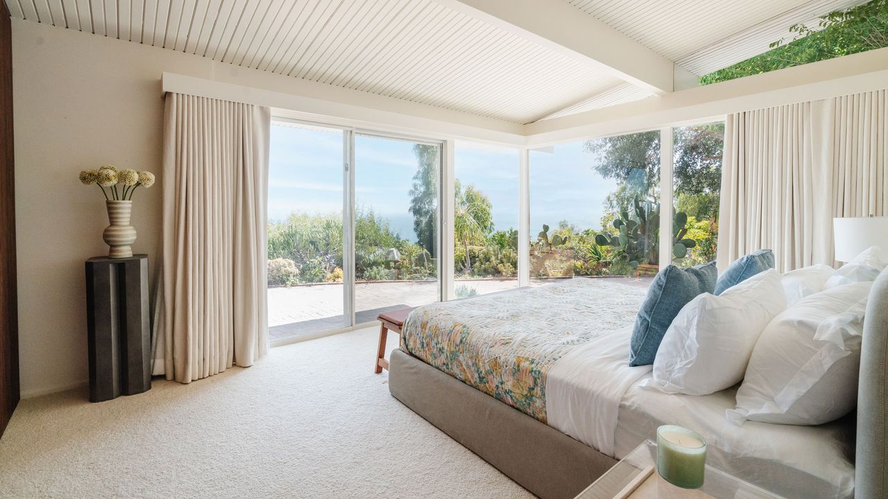 bedroom with white painted walls and large glass windows