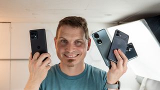 Nicholas Sutrich holding the Motorola Edge Plus (2023), Nothing Phone (2), Honor 90, and OnePlus Nord N30