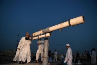 a member of Pakistan Ramadan moon-sighting committee, looks through a telescope for the new moon that signals the start of the Muslim fasting month of Ramadan in Karachi on April 23, 2020.