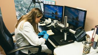 Jennifer Naso, a forensic document examiner, inspects Major Marcel's journal with the aid of a video spectral comparator.