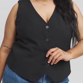 Close up shot of a plus size model wearing a waistcoat on its own, but paired with jeans