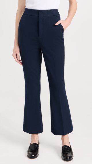 a model wears cropped flare trousers pants in navy blue