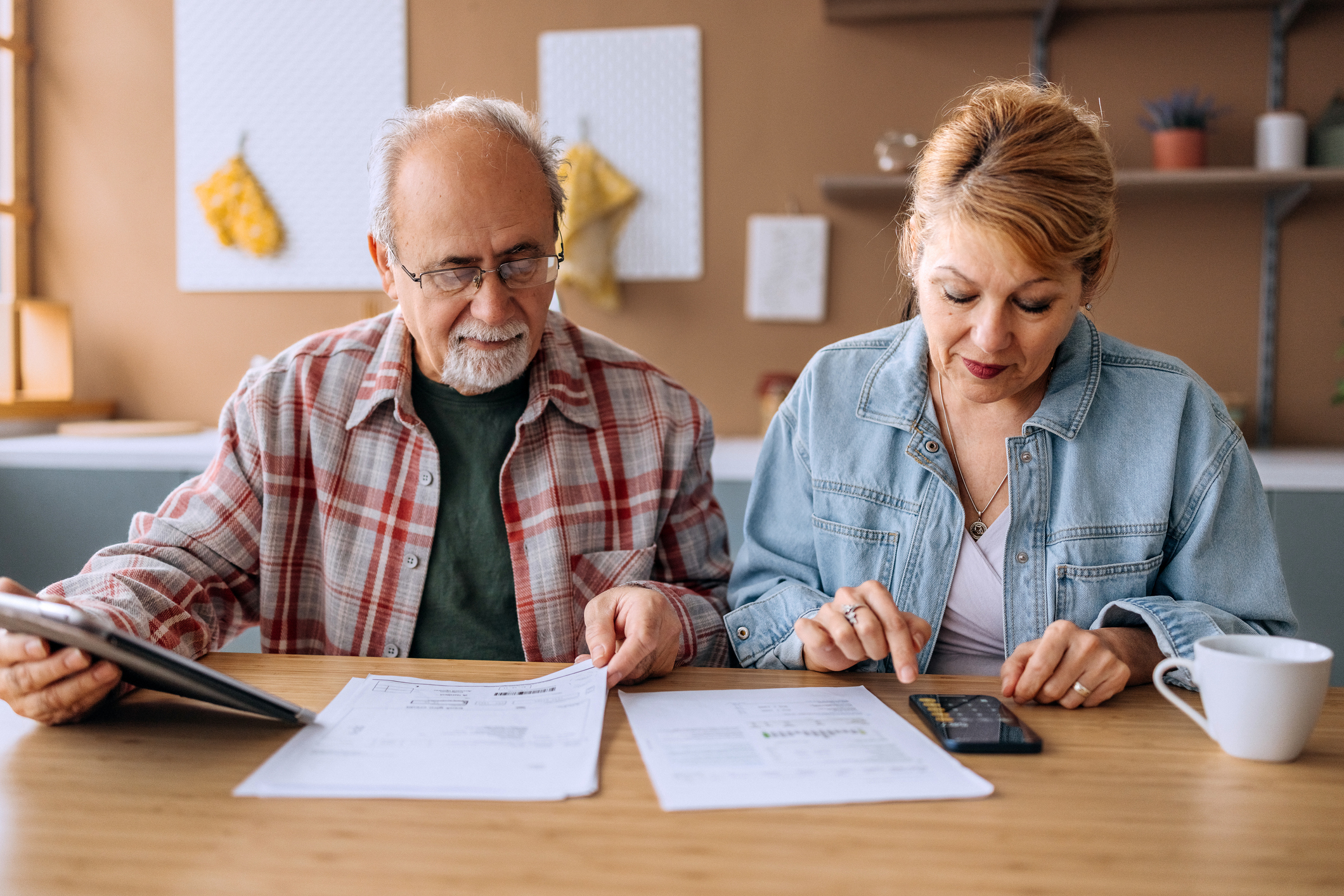 Pensioner couple look at finances as they work out how much they need for a comfortable retirement