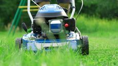 A blue lawnmower cutting grass