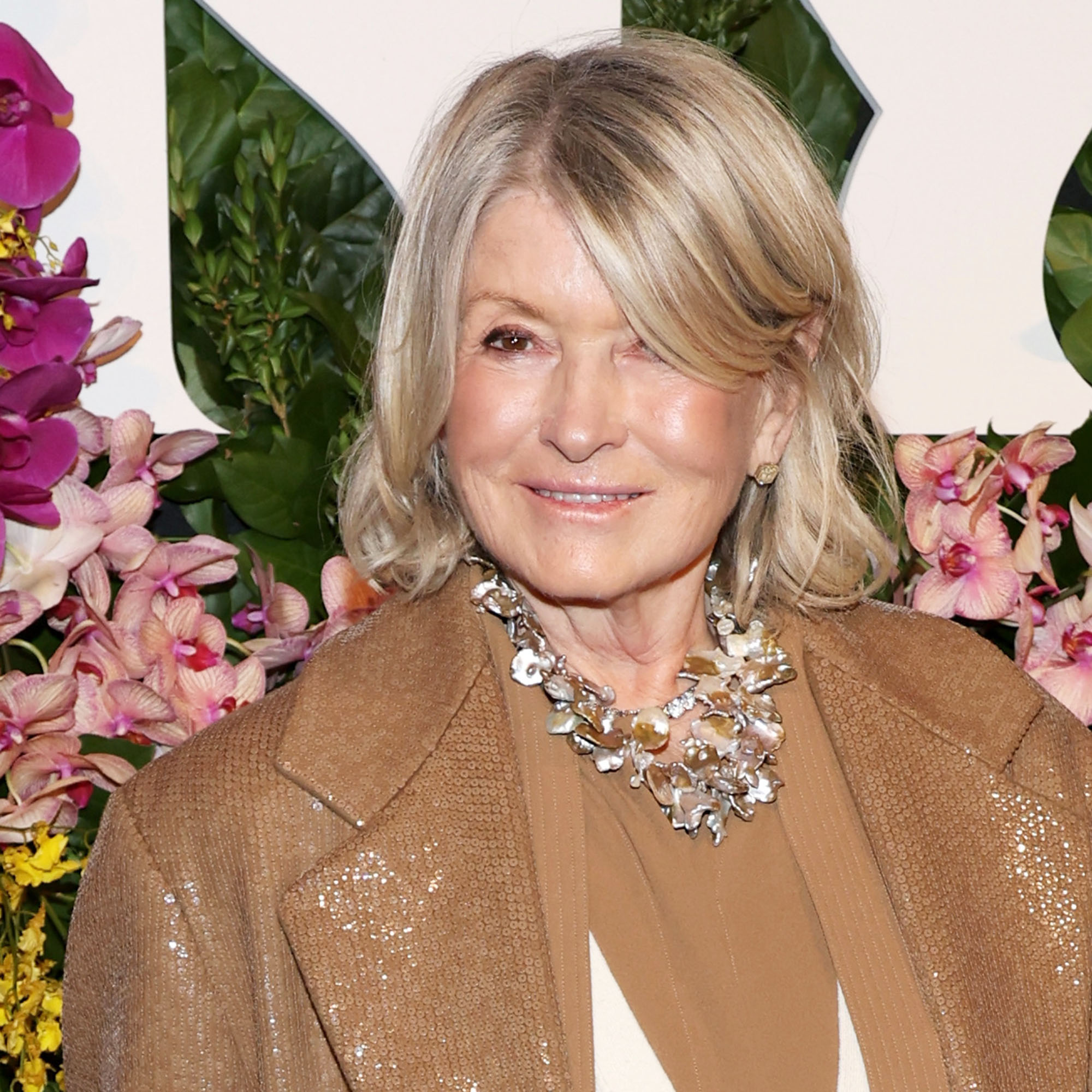 Martha Stewart stands in front of floral background at The New York Botanical Garden hosts The Orchid Dinner at The Plaza Hotel 