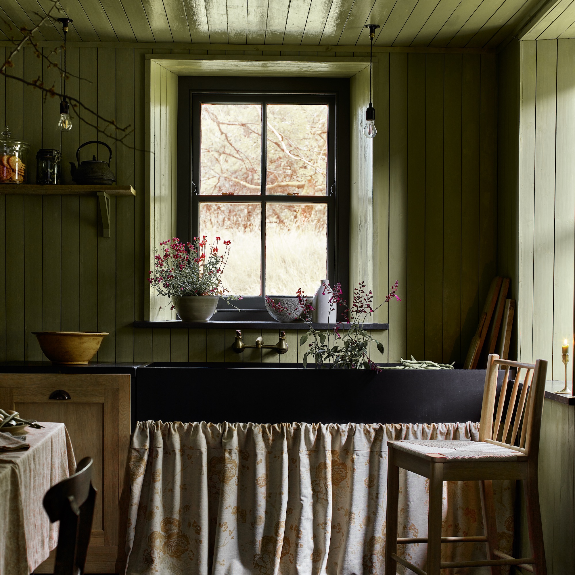 sage green kitchen with green walls and skirt sink