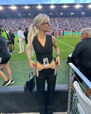 Woman wearing a sequined black outfit to a football game.