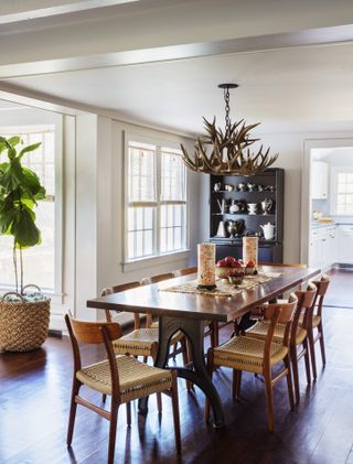Dining room with antler chandelier and bamboo blinds