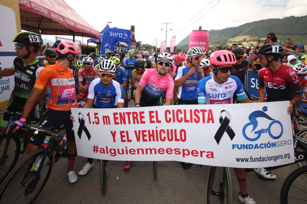 Riders holding up a 1.5m rule sign at Tour Colombia 2.1