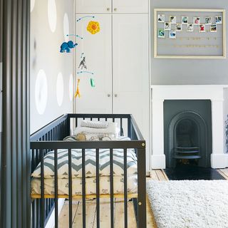 Grey nursery with navy blue cot