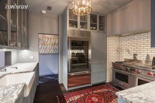 A kitchen with marble countertops and steel oven