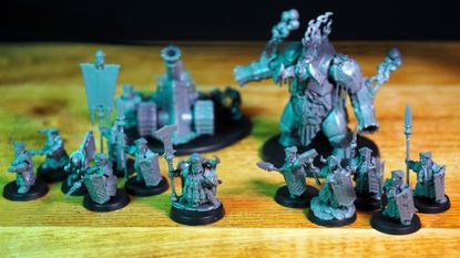 All the Helsmiths of Hashut Army Set models laid out on a wooden table