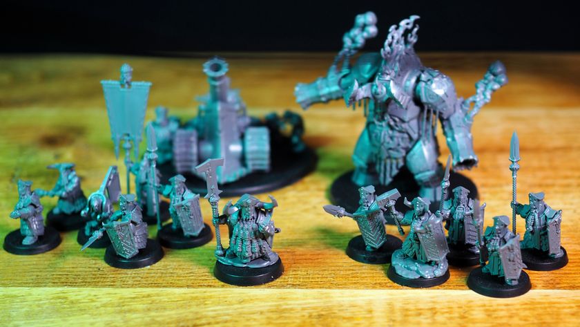 All the Helsmiths of Hashut Army Set models laid out on a wooden table