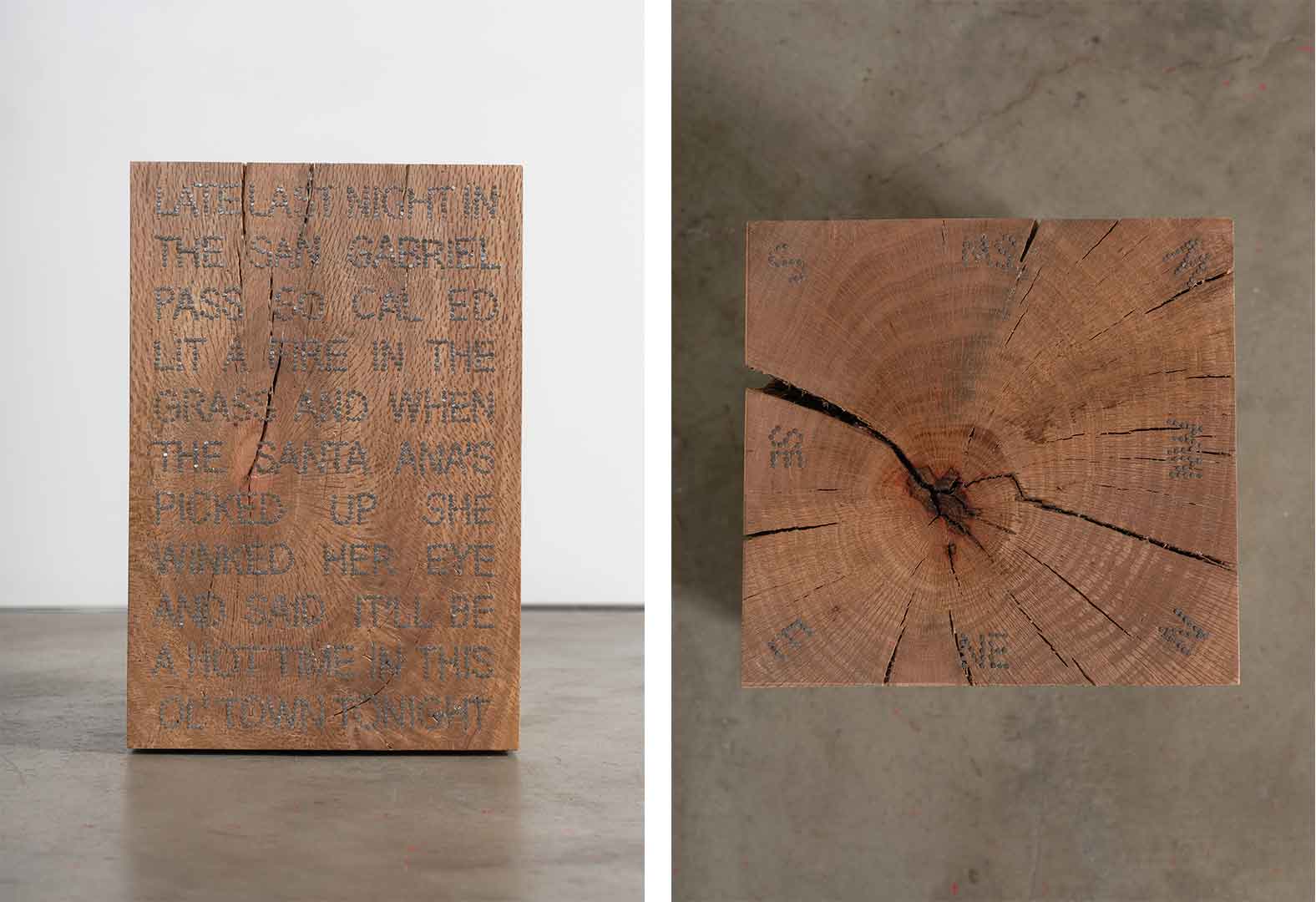 Block of wood with nails spelling words on its surface