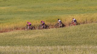 Leading women riding across a grassy expanse in the Tankwa Karoo, Cape Epic 2021