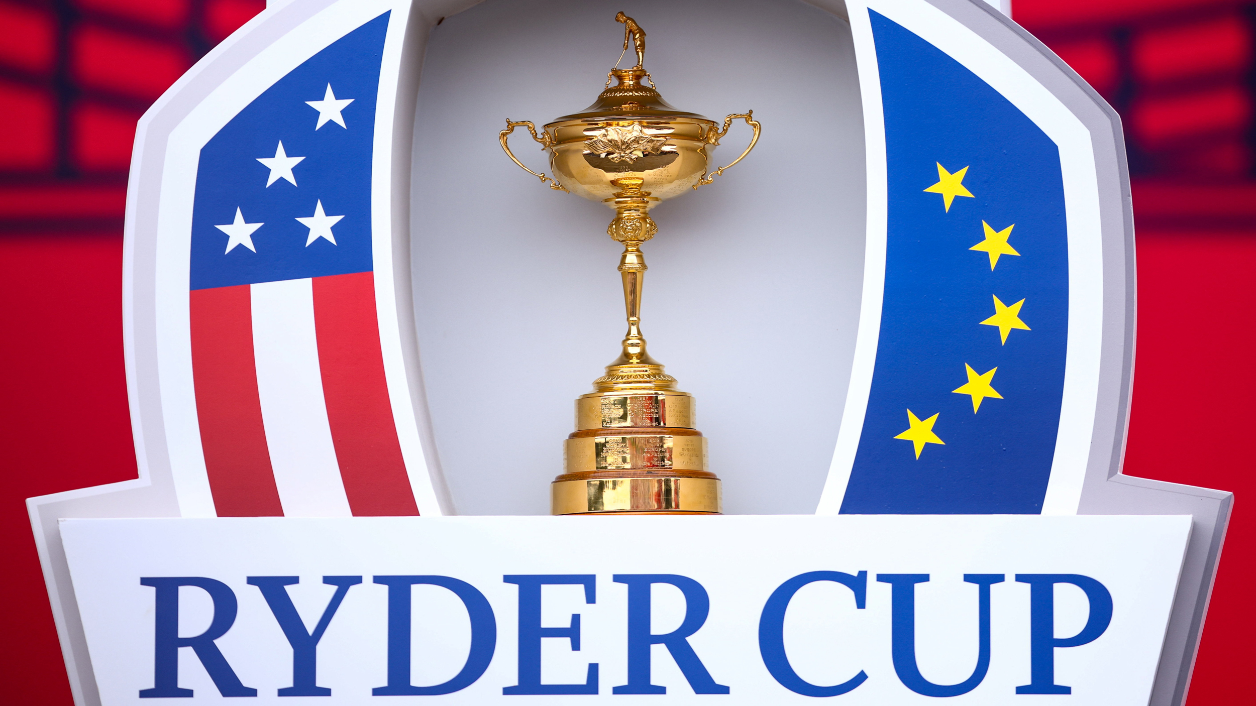 The Ryder Cup trophy above the name of the event and inside the US flag (left) and European flag (right)