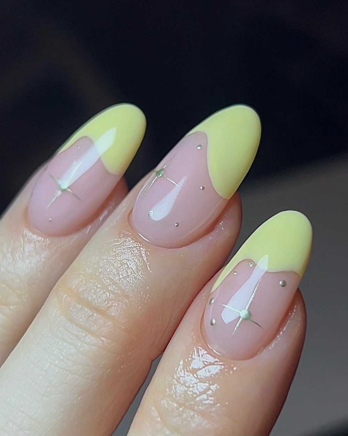 A butter yellow French tip manicure with gold detailing