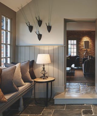 An earthy mudroom and entryway with an alcove bench and stone floor